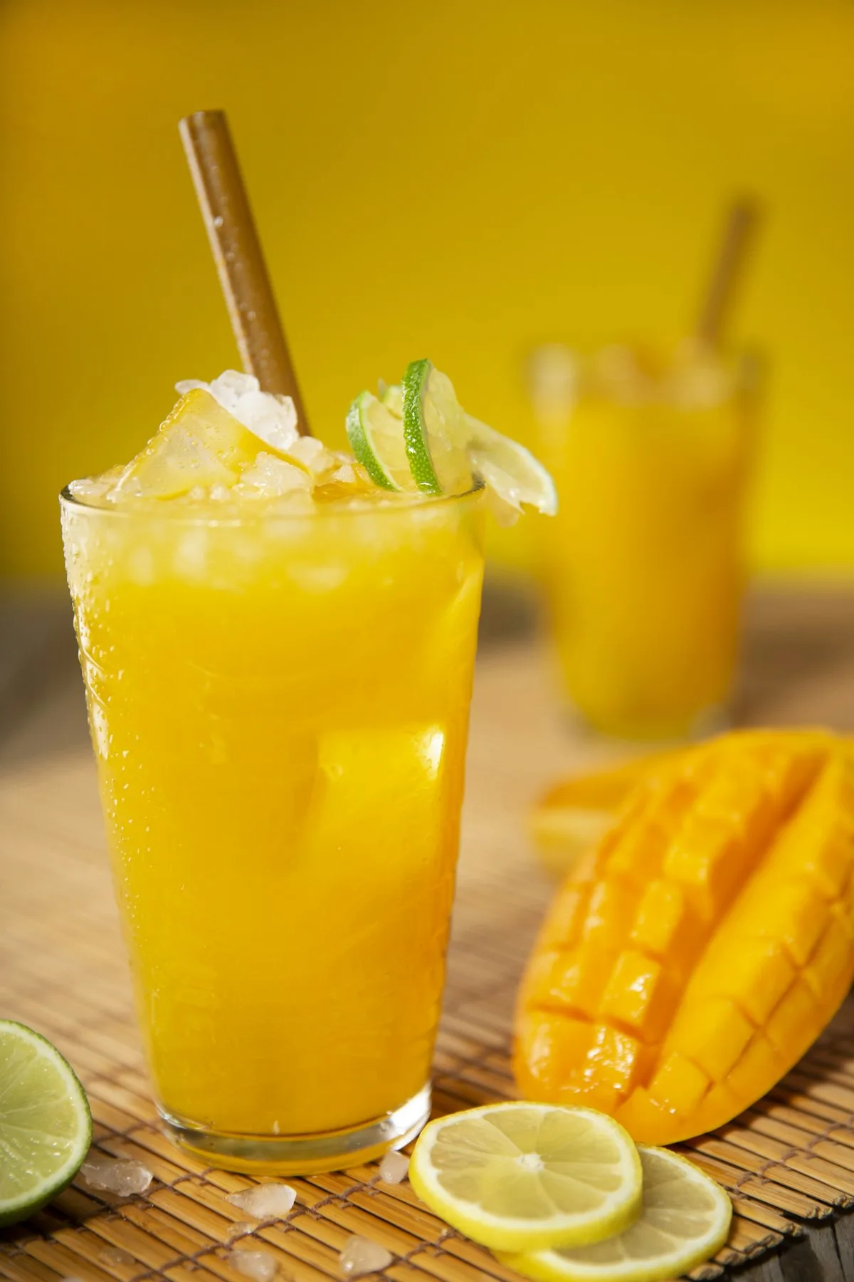 Mango Mayhem — a golden iced mango mocktail with lime in a clear cup